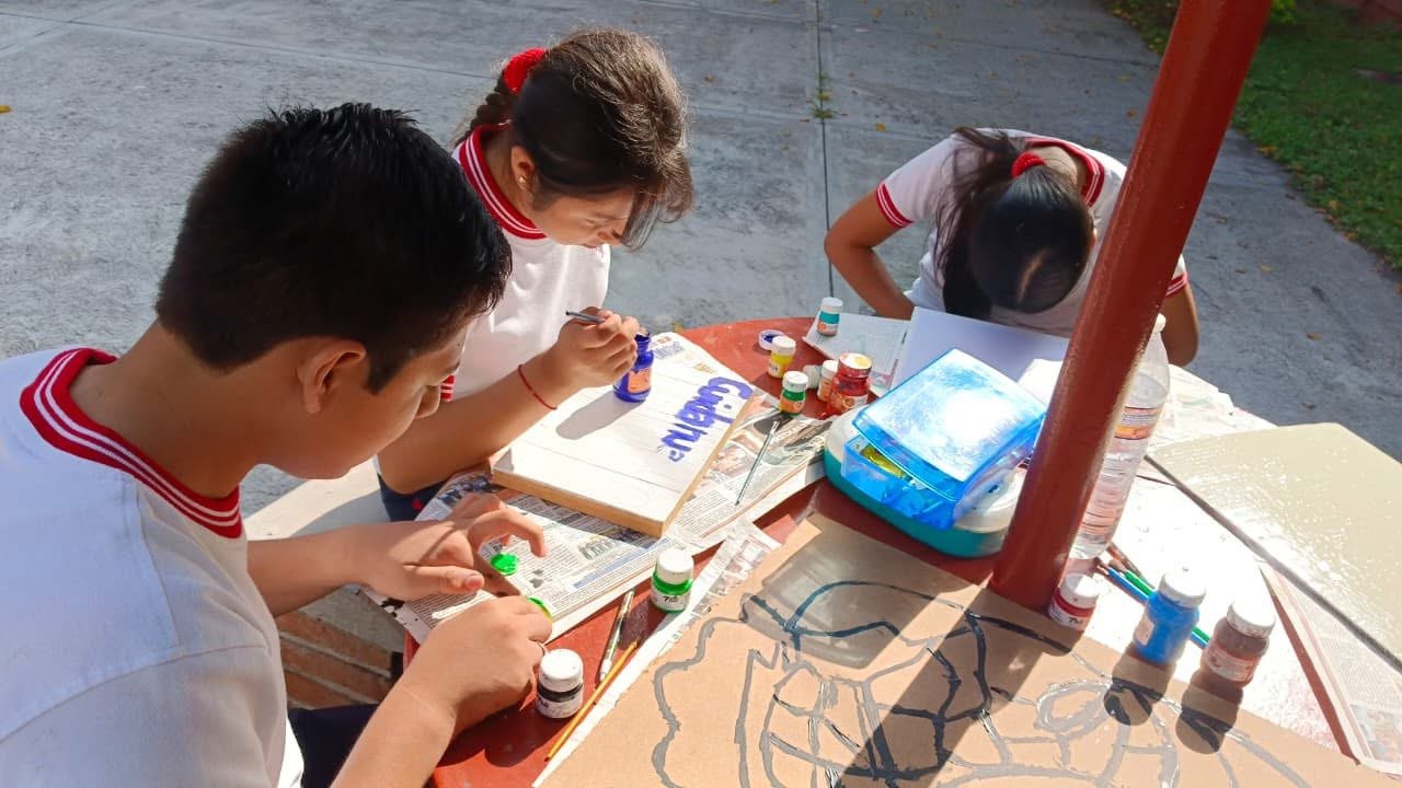 Alumnos pintando en equipo